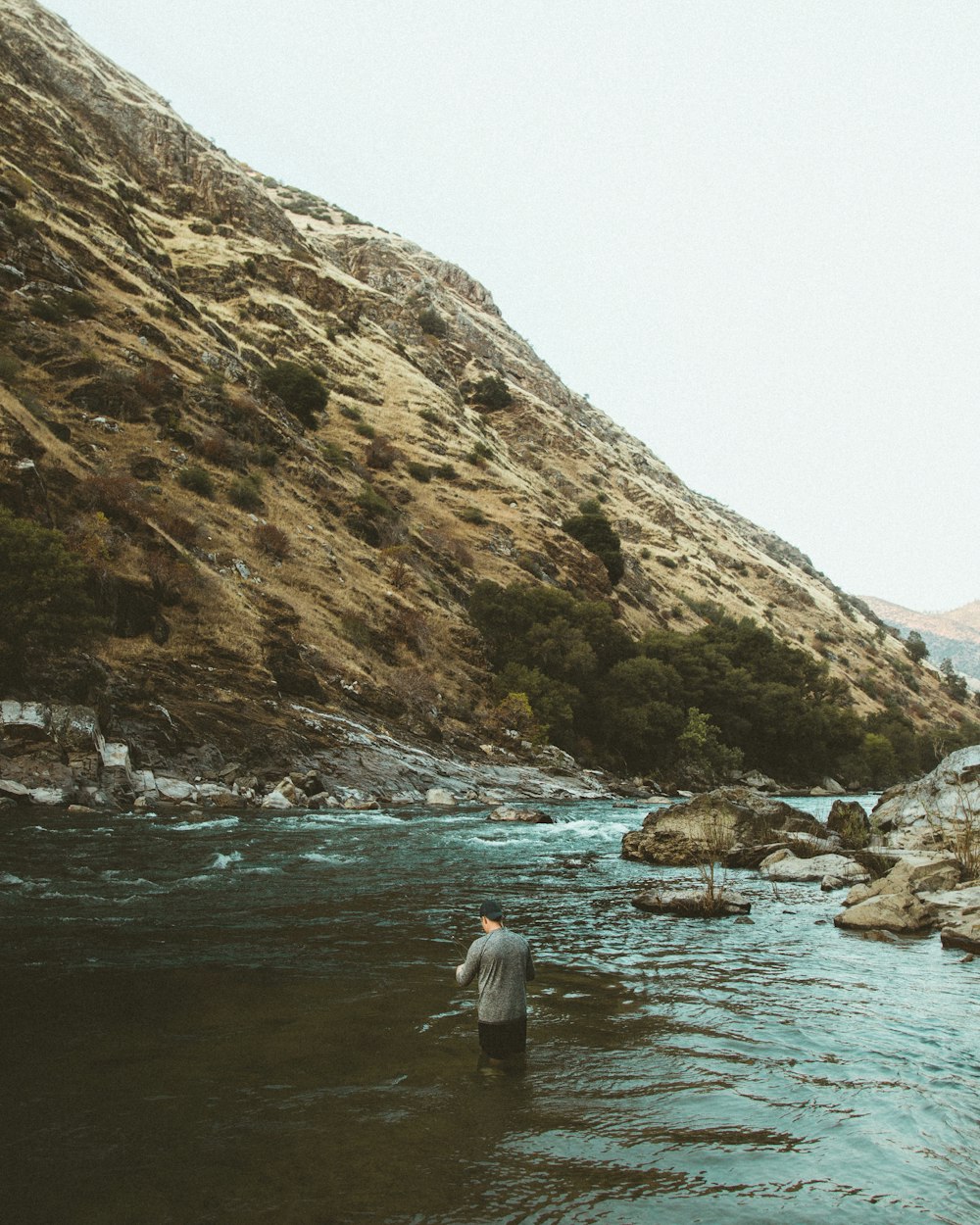 man in water near hill