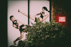 Wall posters of Bruce Lee and Chuck Norris overlooking a lively kickboxing session