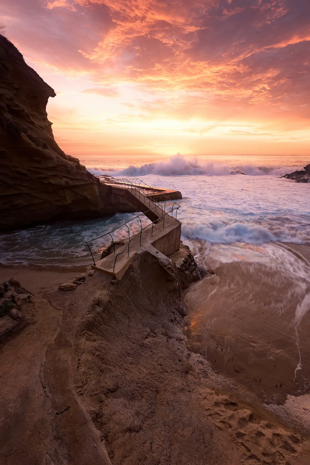 日没時に岩だらけの海岸に打ち寄せる波