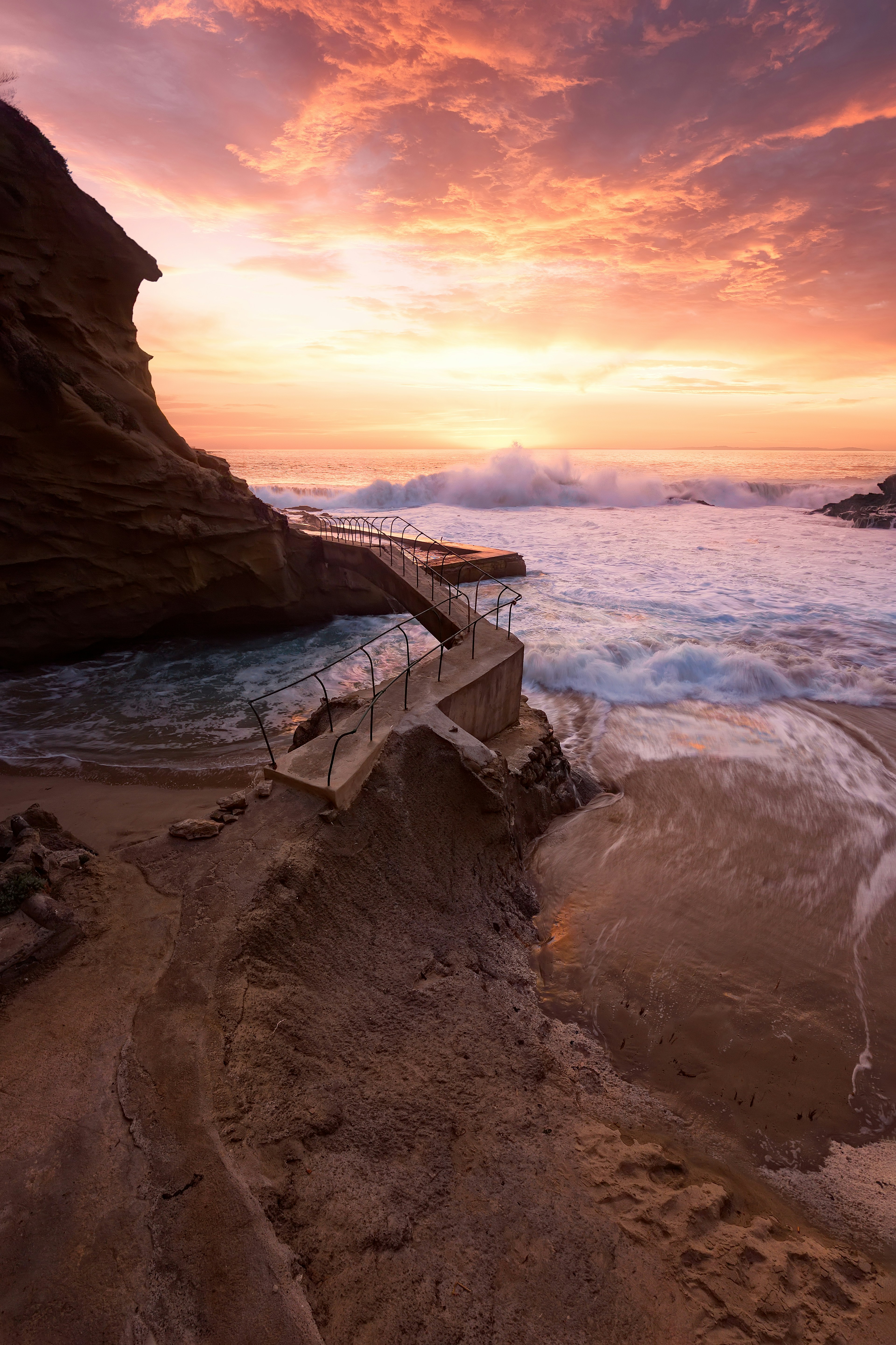 waves crashing on rocky coast during sunset