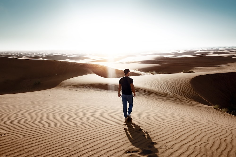 uomo che cammina attraverso l'area desertica