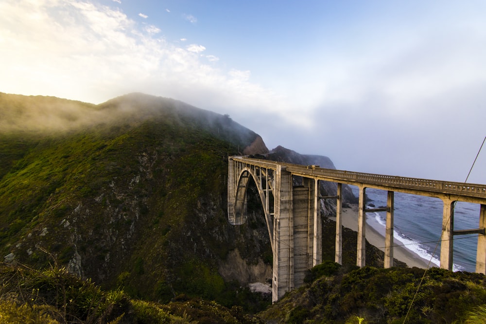 Ponte branca na montanha verde durante o dia