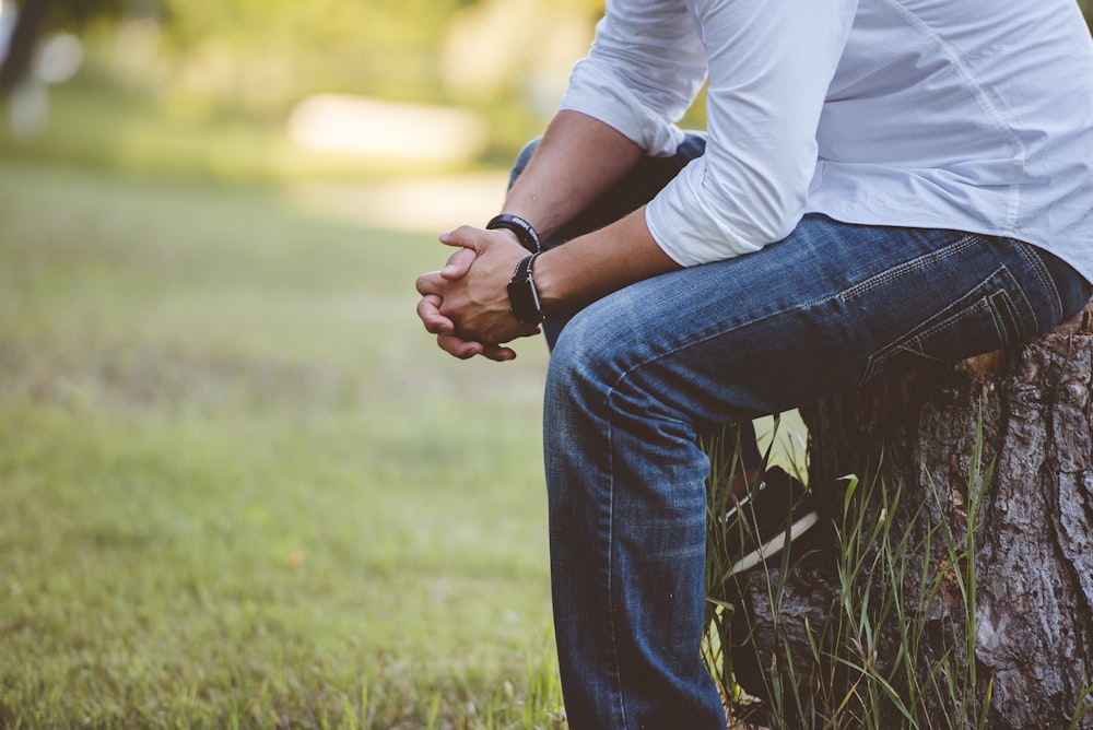 man wearing long sleeved shirt sitting