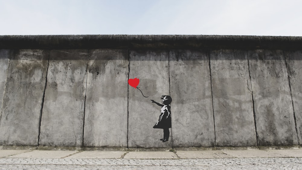 girl playing heart balloon wall artwork