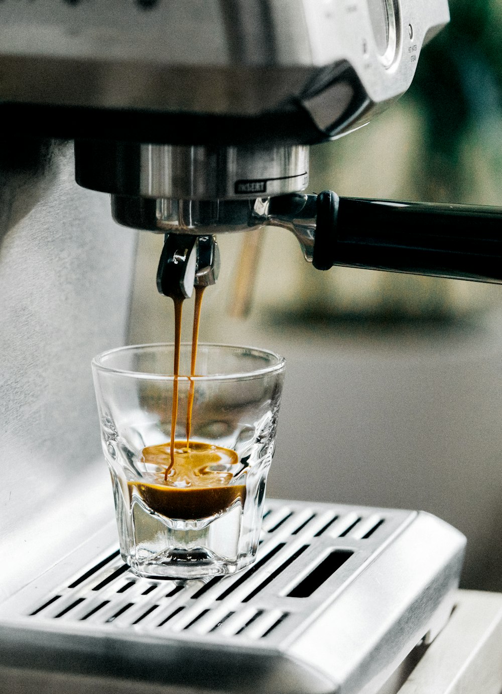 Espresso brewing into a shot glass