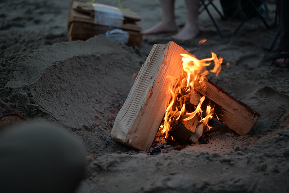 campfire on sand near person