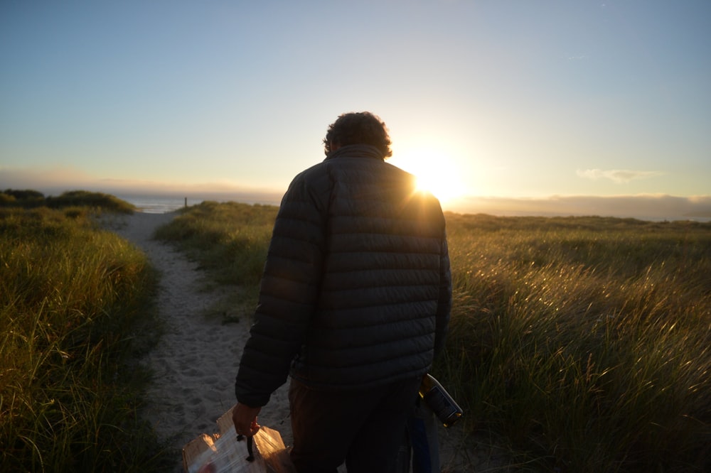 man walking across the road during sunrise