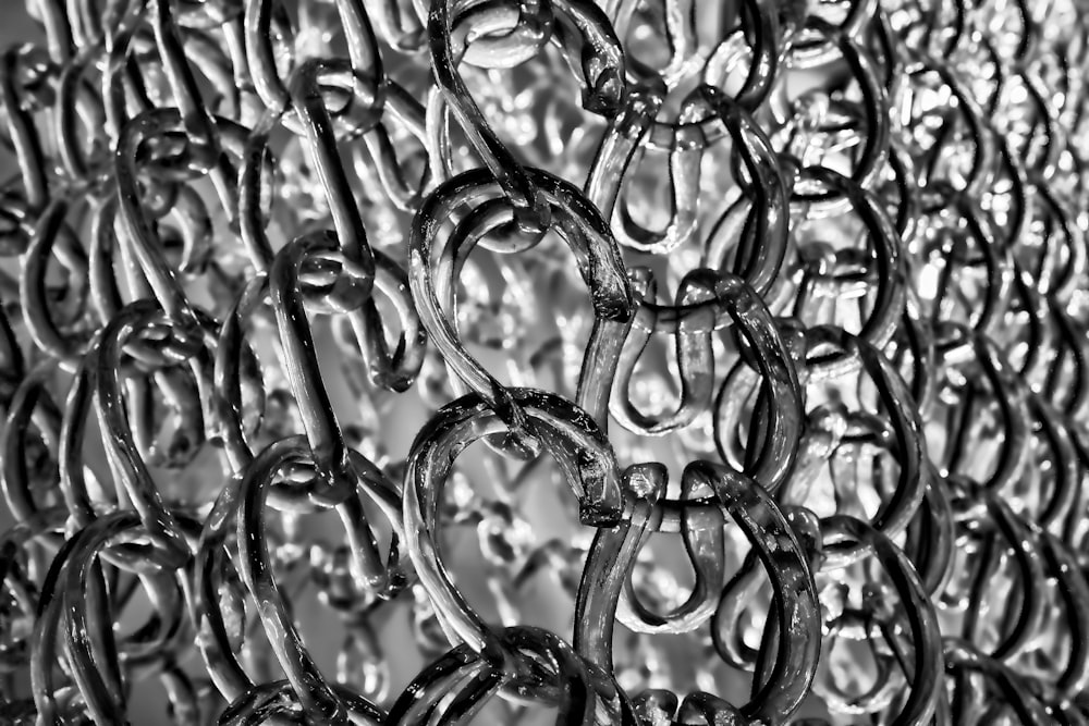 a black and white photo of a chain fence