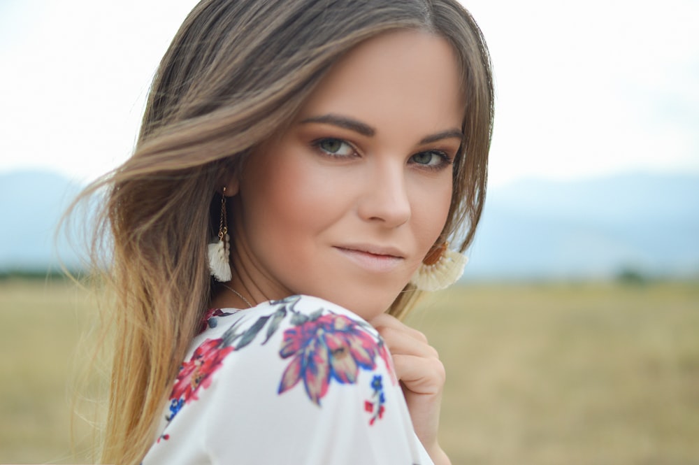 close up photography of woman putting left hand under her chin