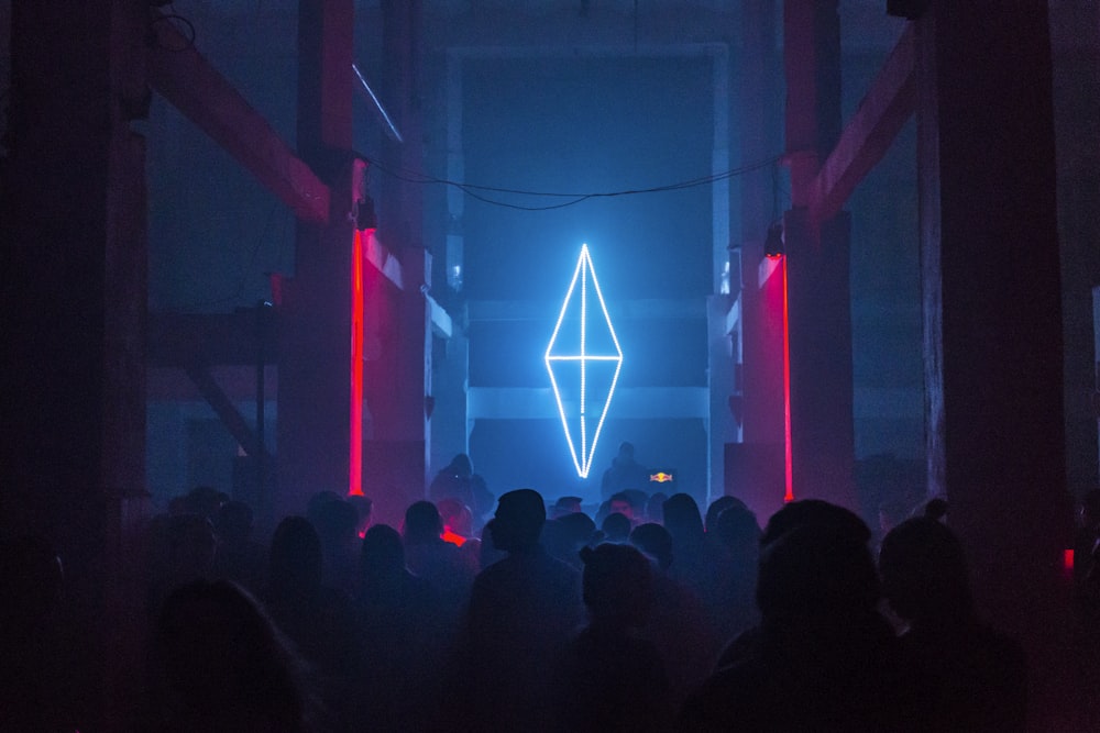 a group of people standing in front of a neon sign