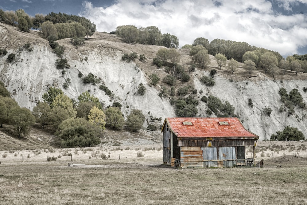 cabin near mountain under cloudy sky