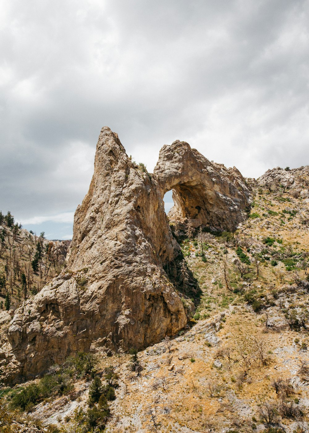 brown land formation under cloudy sky