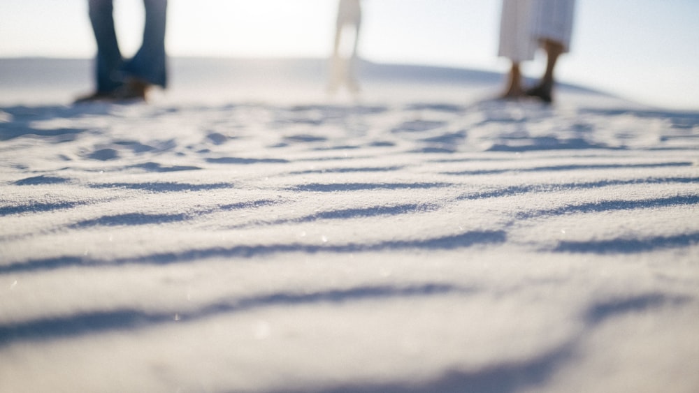 a couple of people standing on top of a snow covered slope