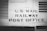 The image features a vintage railway car with the words 'U.S. Mail Railway Post Office' prominently displayed. The surface is metallic and riveted, suggesting an industrial design from the early to mid-20th century. The image is in black and white, enhancing its historical feel.
