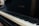 A close-up view of a piano keyboard with the brand name Baldwin visible on the piano body. The keys have a mix of black and white keys with visible shadows.