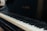 A close-up view of a piano keyboard with the brand name Baldwin visible on the piano body. The keys have a mix of black and white keys with visible shadows.