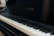 A close-up view of a piano keyboard with the brand name Baldwin visible on the piano body. The keys have a mix of black and white keys with visible shadows.