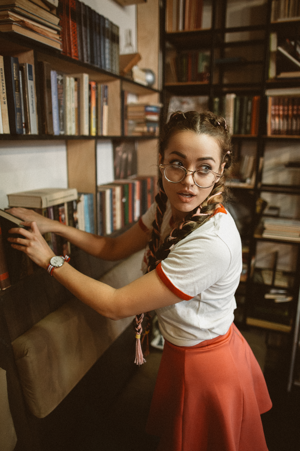 Woman in a vintage outfit putting away a book in a store