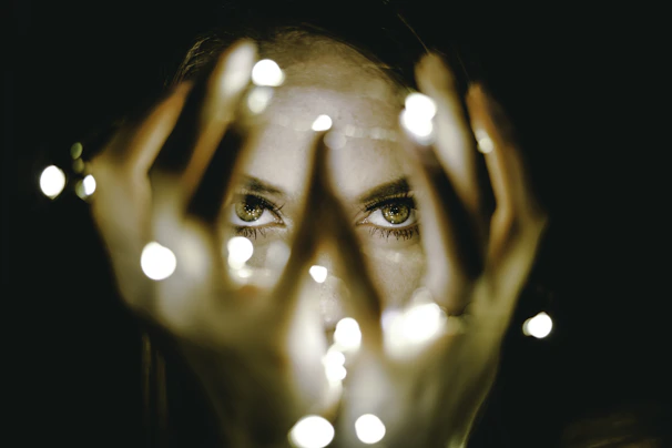 woman holding string lights