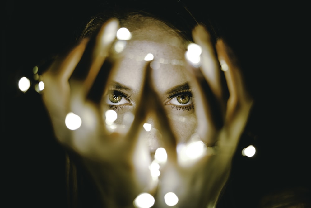 woman holding string lights