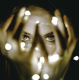 woman holding string lights