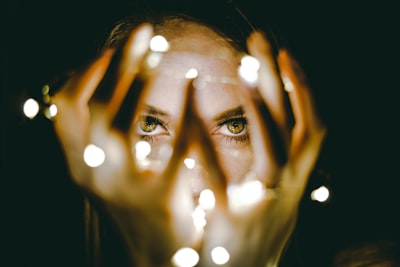 woman holding string lights magic teams background