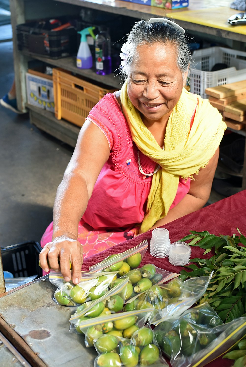 a woman in a yellow scarf is cutting green apples