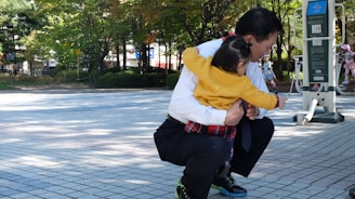 A fit parent exercising outdoors with their child playing nearby, showcasing a balance between fitness and family life.