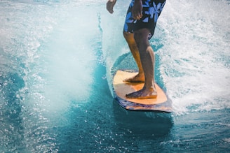 man riding wave with orange surfboard