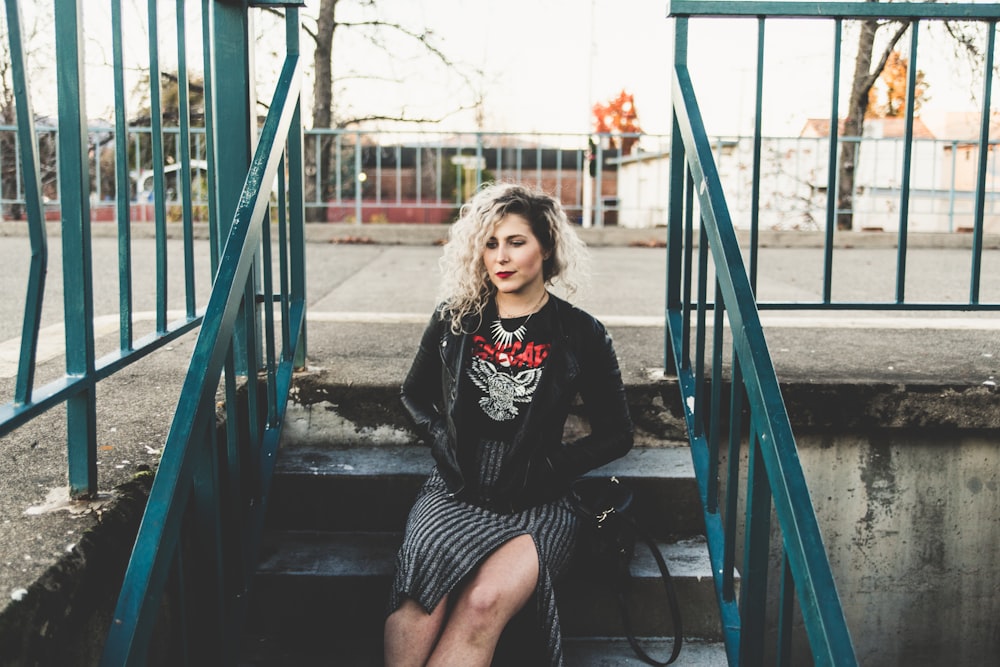 woman sitting on gray concrete stairs