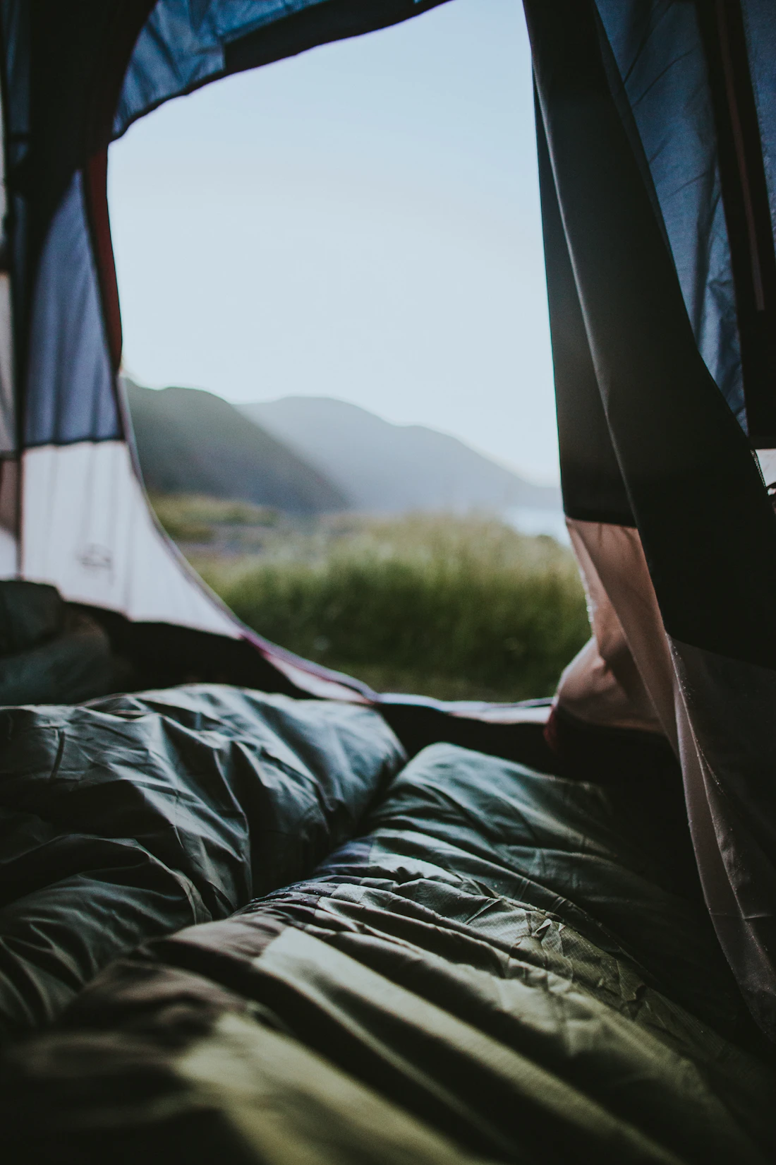 Sleeping bag inside a tent overlooking a natural landscape