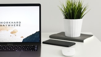 MacBook Pro near green potted plant on table