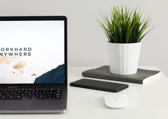 MacBook Pro near green potted plant on table