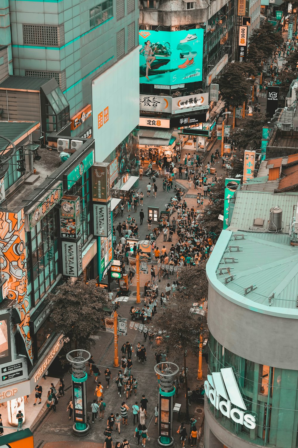 Fotografía aérea de personas caminando por la calle entre edificios
