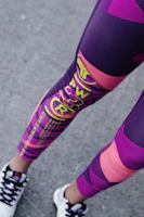 Athlete stretching outdoors wearing bright, elegant sports leggings.