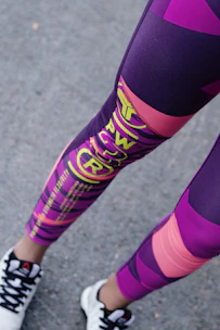 Athletic leggings in deep navy with electric orange stripes running down the sides, worn during a morning run.