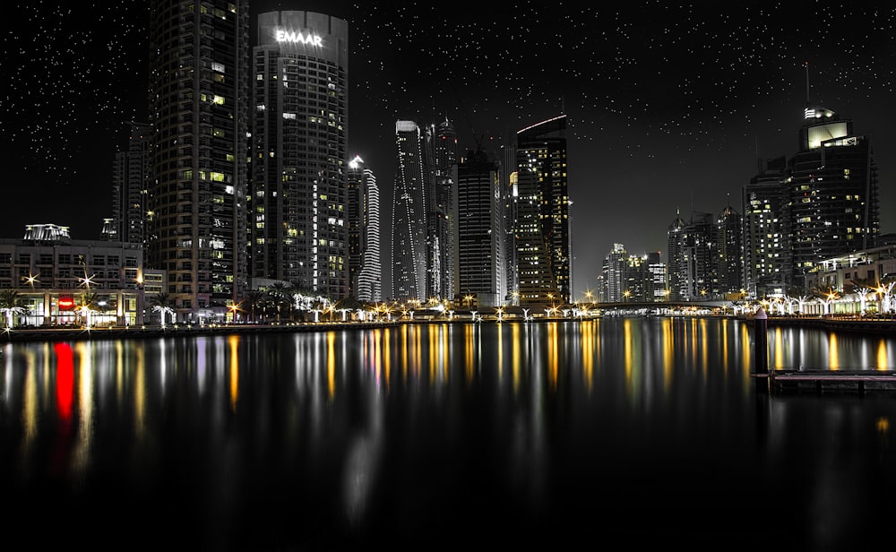 uma cena noturna de uma cidade com luzes refletindo na água