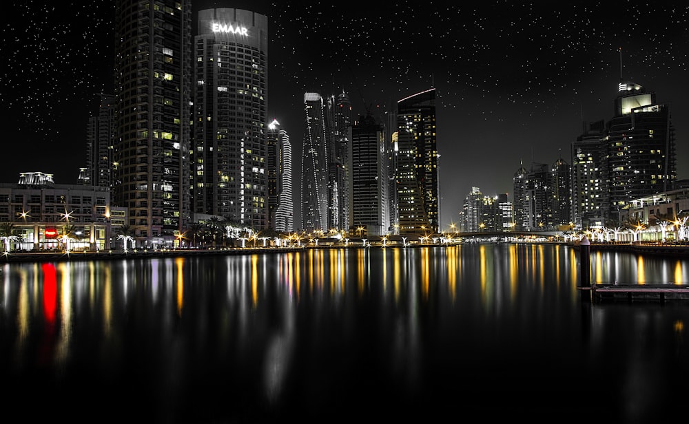 a night scene of a city with lights reflecting in the water
