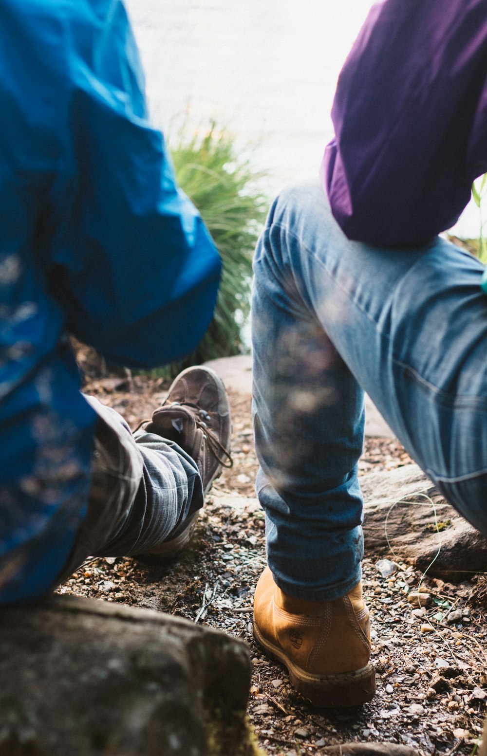 two person sitting on rock wearing blue denim jeans photo