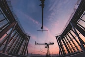 Industrial facility showcasing steel framework and cranes at sunset.