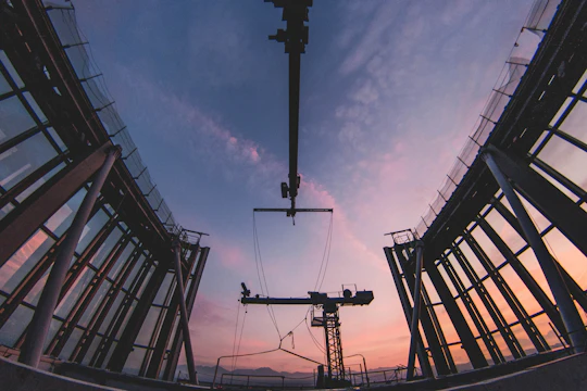 Steel structure installation at an industrial site during sunset.