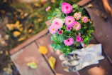 A durable pair of gardening gloves with reinforced palms resting beside blooming flowers.