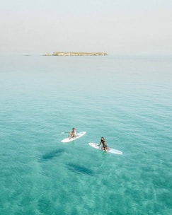 Guests enjoying paddleboarding and snorkeling in calm, turquoise waters near Marbella.