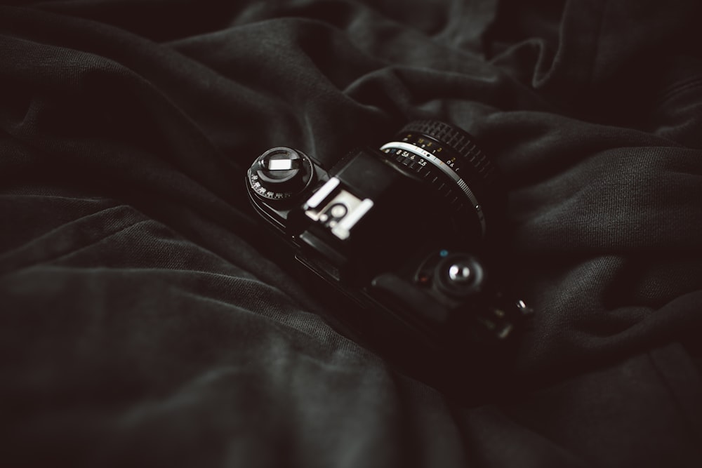 DSLR camera on top of black blanket