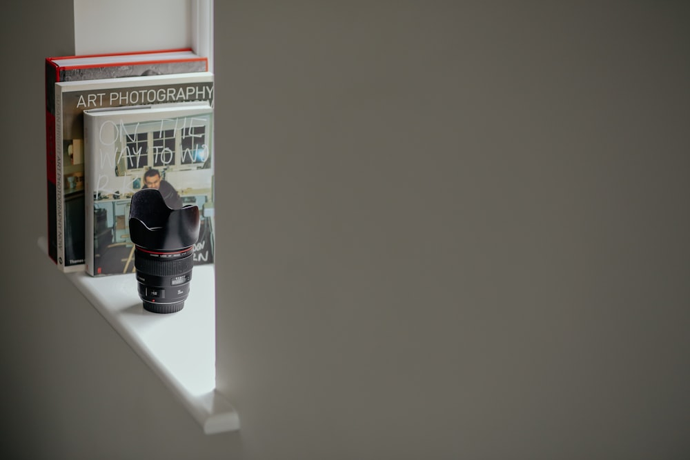 a camera sitting on top of a shelf next to a book