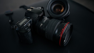 black Canon DSLR camera beside camera lens