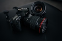 black Canon DSLR camera beside camera lens