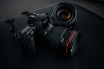 black Canon DSLR camera beside camera lens