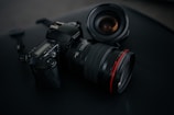 black Canon DSLR camera beside camera lens