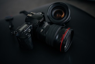 black Canon DSLR camera beside camera lens